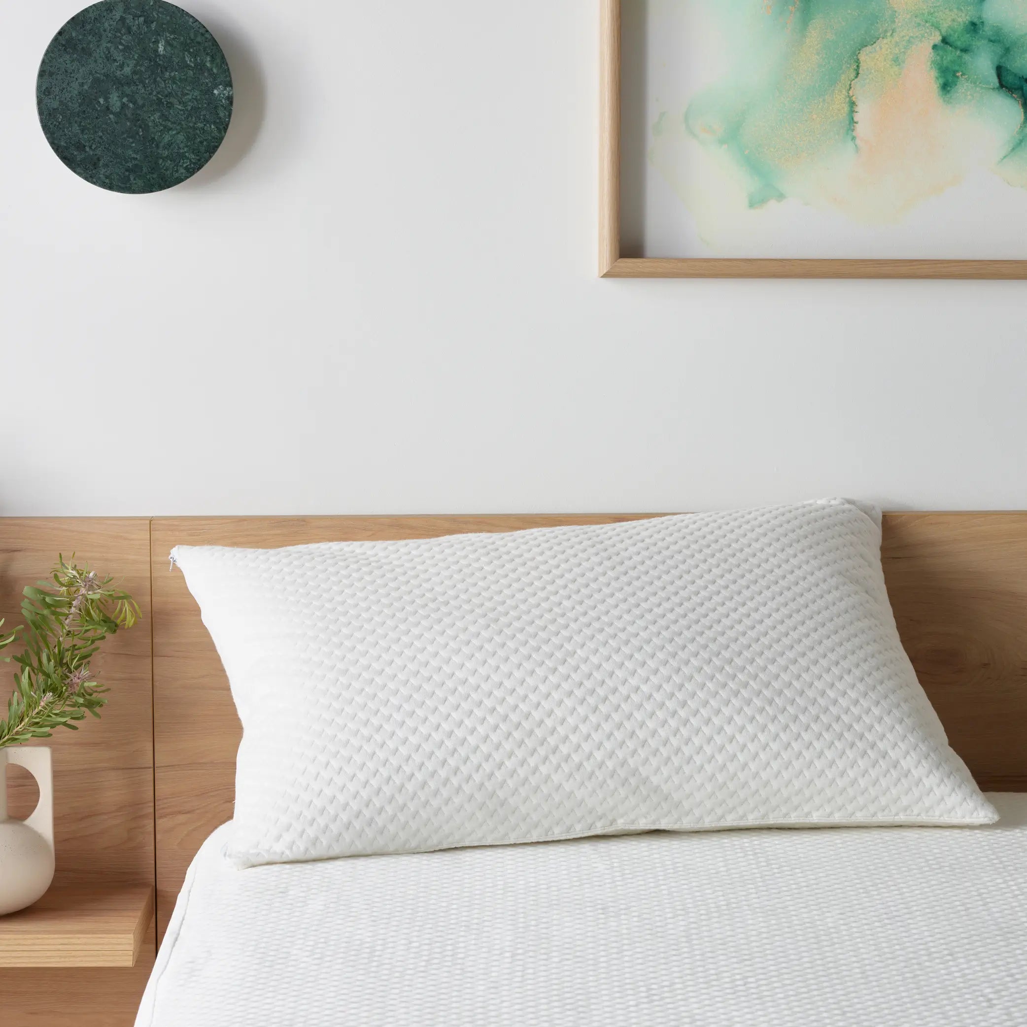 A close-up of a luxurious white pillow encased in the DuraDeluxe Waterproof Pillow Protector with a textured quilted design. Ultra-soft, breathable and waterproof pillow cover.